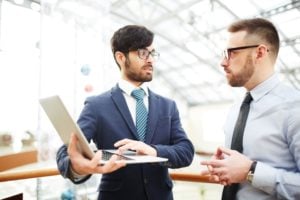 Dois homens conversando sobre as ações ITSA4 da Itaúsa