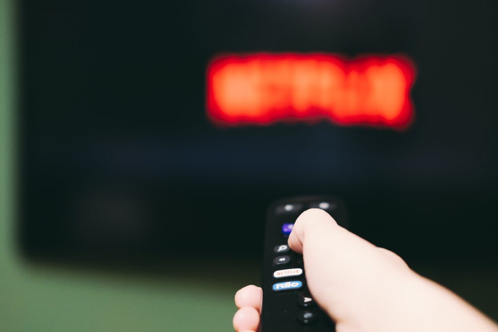 Pessoa assistindo Netflix e comprando ações NFLX34
